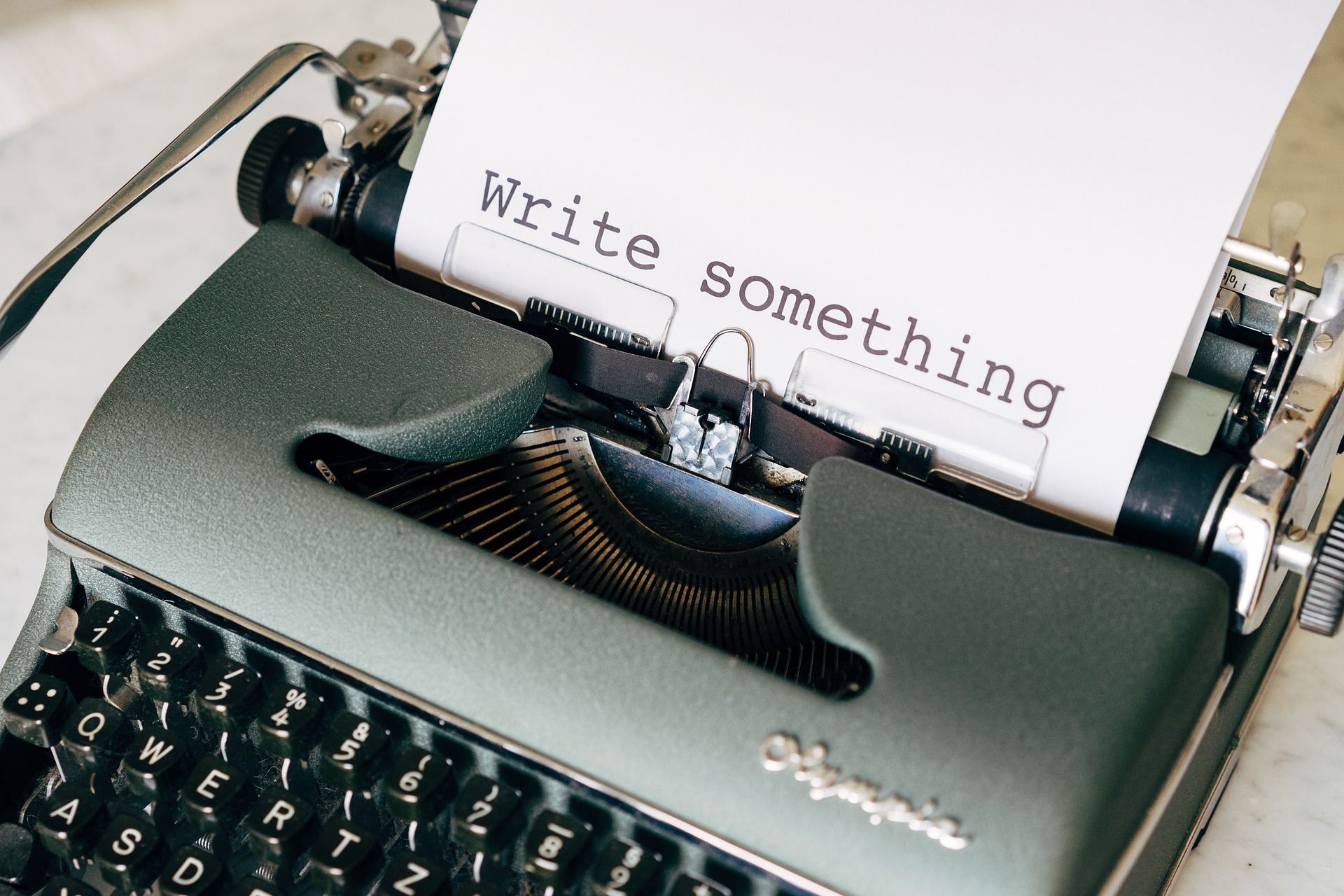 Alt='Old type writer with a typed paper on process written , write something"